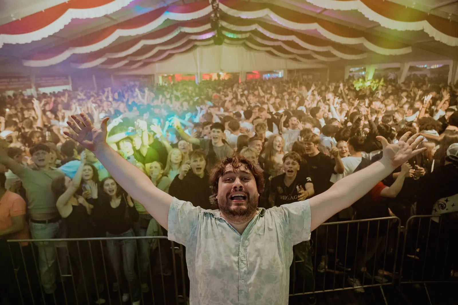 Peter Englert mit ausgebreiteten Armen vor einem feiernden Publikum im Festzelt